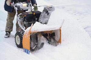 Clear snow from driveway after a winter cyclone using a snow blower photo