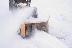 After the snowy winter cyclone, a snow blower machine was used to remove the snow from the driveway photo