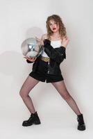 Portrait of young woman dancer holding mirror disco ball, looking at camera. Young adult pin up girl photo