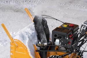 In this extreme close-up view, you can see a snow blower being used to clear snow from a driveway photo