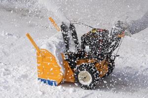 Snow blower machine is used to remove snow from driveway after snowy winter cyclone photo