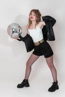 Portrait of smiling woman dancer holding disco ball and looking at camera. Young adult pin up girl photo