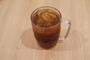 Ice tea in glass on wooden table. Selective focus and shallow depth of field. photo