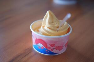 ice cream in paper cup on wood table background. soft focus. photo