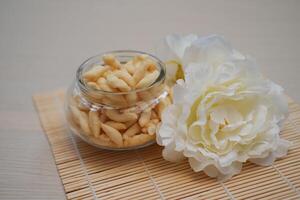 telur gabus in glass jar and white flower on bamboo mat photo