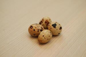 Quail eggs on a wooden background. Close-up, selective focus. photo