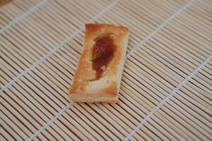 Biscuits with jam on a bamboo placemat. Selective focus. photo