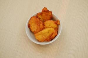 Corn croquettes in a bowl on a wooden table, top view photo
