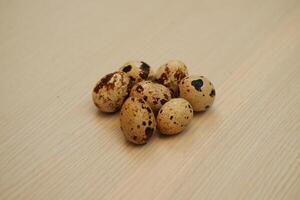 Quail eggs on a wooden background. Close-up, selective focus. photo
