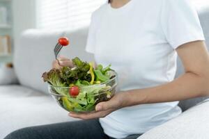 dieta y haciendo dieta, disfrutar comer. sano mujer sostener ensalada comida y sensación contento. belleza Delgado hembra cuerpo logra peso pérdida objetivo para sano vida, loco acerca de delgadez, Delgado cintura, nutricionista. foto