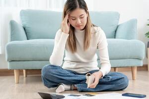 Stressed and headache asian woman with large bills or invoices no money to pay to expenses and credit card debt. shortage, Financial problems, mortgage, loan, bankruptcy, bankrupt, poor, empty wallet photo