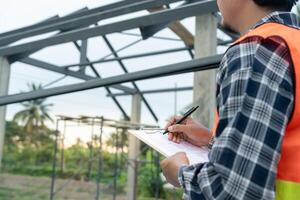 inspector or engineer is inspecting construction and quality assurance new house using a checklist. Engineers or architects or contactor work to build the house before handing it over to the homeowner photo