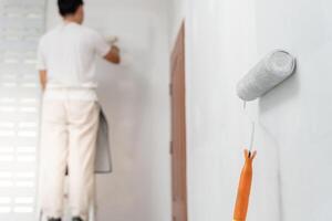 pintor hombre, cepillo en mano para productos a restaurar y pintar el muro, interior el edificio sitio de un casa, pared durante cuadro, renovación, cuadro, contratista, arquitecto, construcción trabajador foto