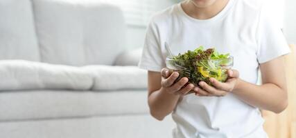 dieta y haciendo dieta, disfrutar comer. sano mujer sostener ensalada comida y sensación contento. belleza Delgado hembra cuerpo logra peso pérdida objetivo para sano vida, loco acerca de delgadez, Delgado cintura, nutricionista. foto