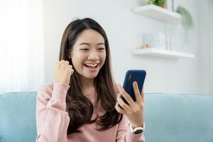 Asian woman exited surprise face expression . female feels shocked with the phone. exciting smile and happy adorable rejoices. Very enjoy and fun relax time. wow, girl holding smartphone. photo