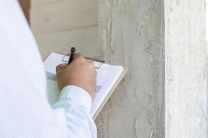 inspector or engineer is inspecting construction and quality assurance new house using a checklist. Engineers or architects or contactor work to build the house before handing it over to the homeowner photo
