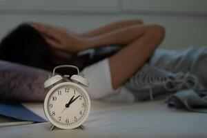 mujer en cama tarde molesto a dormir sufrimiento insomnio, insomne o asustado en un pesadilla, mirando triste preocupado y estresado. cansado y dolor de cabeza o migraña despertar arriba en el medio de el noche. foto