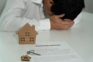 Business man is stressed due to imminent seizure of assets, debts, financial problems, loans, guarantees document with the text eviction notice, debt, property, loan, agent, bankruptcy photo