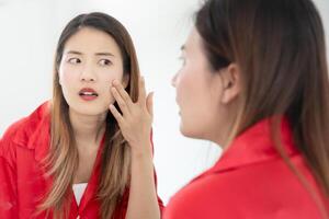 Young woman are worried about faces Dermatology and allergic to steroids in cosmetics. sensitive skin, red face from sunburn, acne, allergic to chemicals, rash on face. skin problems and beauty photo