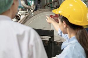 Engineers or utility staff wearing safety helmet fix the machines in the production line. Utility inspector check machine and test the system to meet the standard. machine, Preventive Maintenance photo