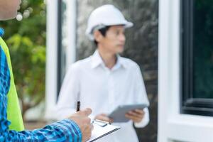 inspector or engineer is inspecting construction and quality assurance new house using a checklist. Engineers or architects or contactor work to build the house before handing it over to the homeowner photo