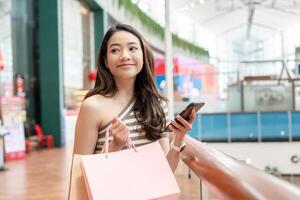 woman using smartphone for online shopping at home. Hand holding mobile phone with payment detail page display and credit card, stay home, technology, electronic commerce, internet, market place photo