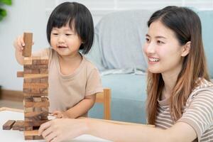 Asia Happy single mother playing learning games janga with the little boy. Funny family is happy and excited in the house. Father and son having fun spending time together. holiday, weekend, vacant. photo