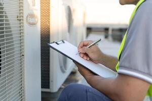 maintenance engineer works on the roof of factory. contractor inspect compressor system and plans installation of air condition systems in construction. Checklist, inspector, control photo