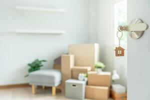 Moving house, relocation. The key was inserted into the door of the new house, inside the room was a cardboard box containing personal belongings and furniture. move in the apartment or condominium photo