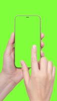 A womans hand holds a phone chromakey Mockup and the second hand with a finger scrolls. Isolated on chromakey background animation vertical video