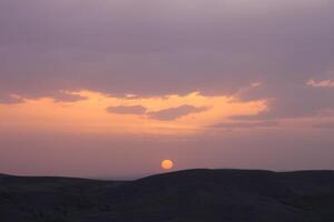 un puesta de sol con nubes y un naranja Dom ajuste en el cielo. foto