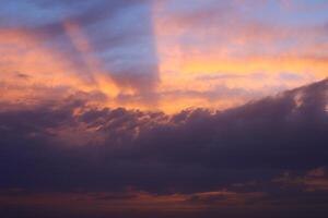 a sunset sky with clouds and a purple sky with a few clouds. photo