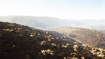 maravilloso Disparo de un brumoso rocoso paisaje con parcial césped cobertura video