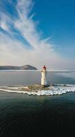 Aerial view of the lighthouse in winter in the ice at dawn photo