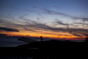 naranja roja cielo a puesta de sol en crepúsculo noche con oscuro nubes y Luna. naturaleza cielo. fondo, horizonte dorado cielo, amanecer nube magnífico, crepúsculo cielo. foto