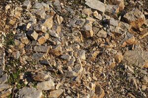 Red rocks of different shapes and sizes on the ground. Orange texture. Background. For text. For banner. Horizontal photo