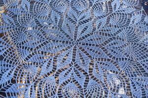 Blue handmade lace. Lace round tablecloth. Lace crochet patterns. Rustic hand crochet lace in sunshine. Horizontal photo