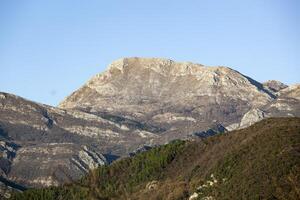 Spring in the mountains, beautiful mountain landscape. View of the mountain range and green trees. Summer, autumn and winter. Budva, Montenegro. Europe. Background. For text. Banner. Postcard. photo