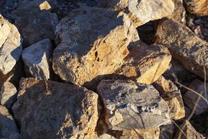 Red rocks of different shapes and sizes on the ground. Orange texture. Background. For text. For banner. Horizontal photo