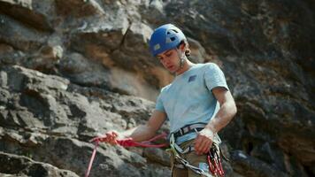 Climber man preparing for climbing up the rocky wall rift by checking rope. Climbing extreme active sport activity. Active people, outdoor activities.Rope detail shot.Slow motion 4k . video