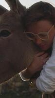 Intimate Embrace Between Human and Animal. A Woman Hugging a Donkey in a Display of Affection and Connection with Nature. video