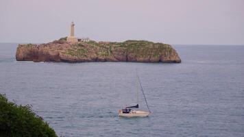 Small boat sailing towards lighthouse video