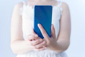 Close-up of female hands holding a cell phone. Using technology. photo