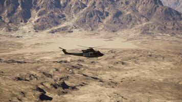 A helicopter flying over a mountain range in the desert photo