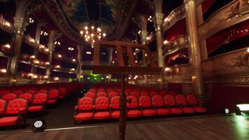 An empty theater with red seats and chandeliers photo