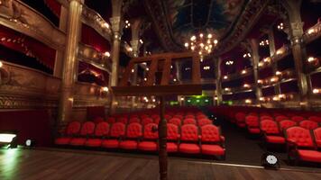 An empty theater with red seats and chandeliers photo