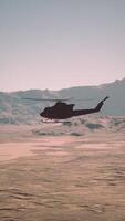 Helicopter Flying Over Desert Landscape photo