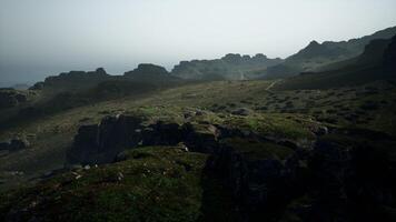 un brumoso ver de un rocoso montaña rango. montaña camino foto