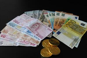 turco billetes de banco, nosotros dólar y europeo Unión dinero en negro antecedentes. Finanzas y economía foto