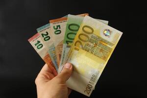 man counting euro money with his hand. euro banknotes. The paper currency of europan union .Calculator in the background. photo